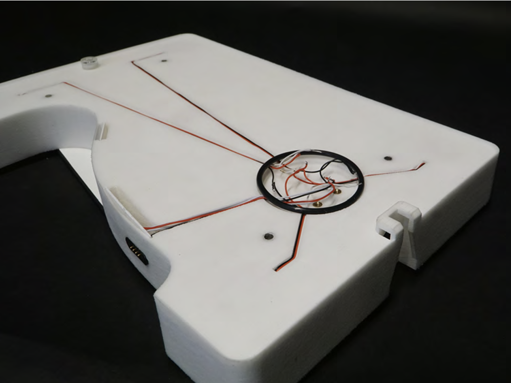 Scale prototype with sensor wiring routed through the white measuring platform and gathered in a central opening.