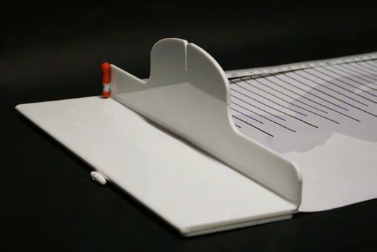 Side view of the acrylic headrest connected to the infant measuring mat.