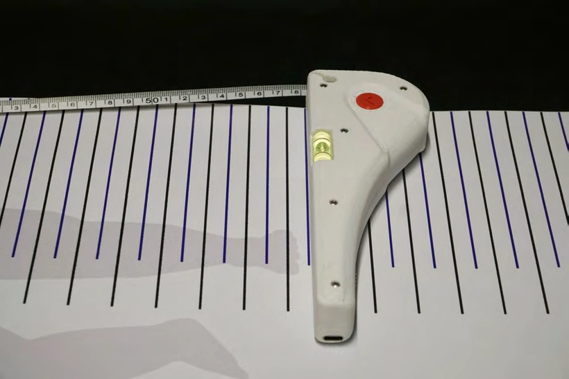 Handheld aligned with the marked measuring lines on the infant mat.